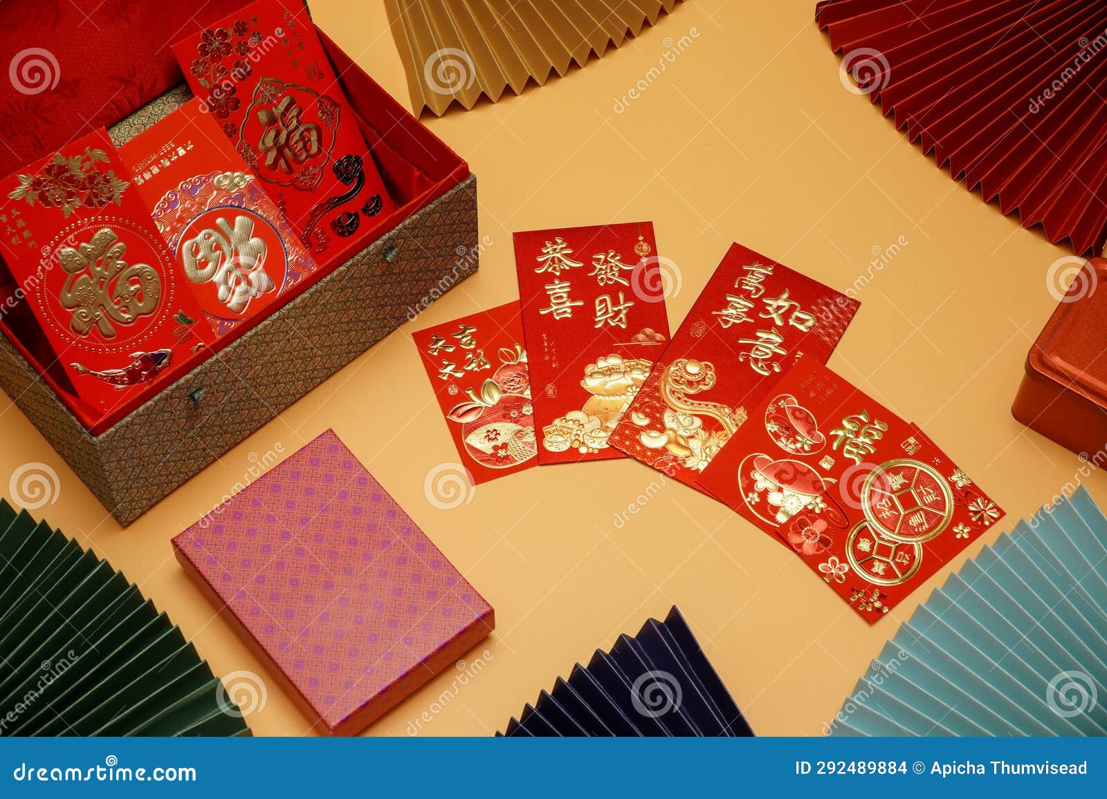 money cheats and chinese new year red packets are placed on an orange background,pictured text: prosperous, springtime text space