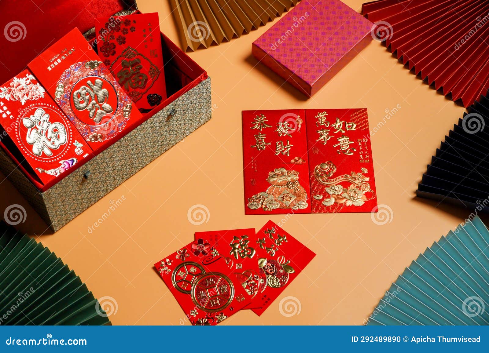 money cheats and chinese new year red packets are placed on an orange background,pictured text: prosperous, springtime text space