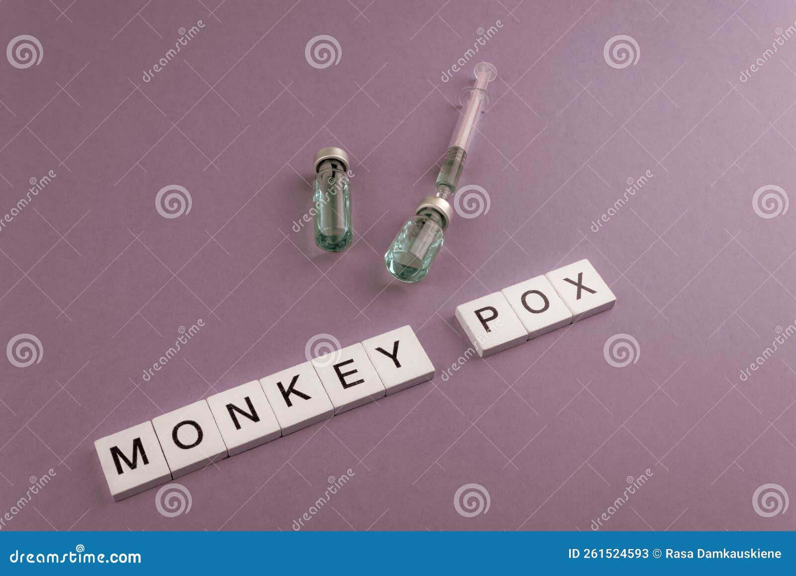 monkey pox. words written on square wooden tiles with vaccine on pink background.