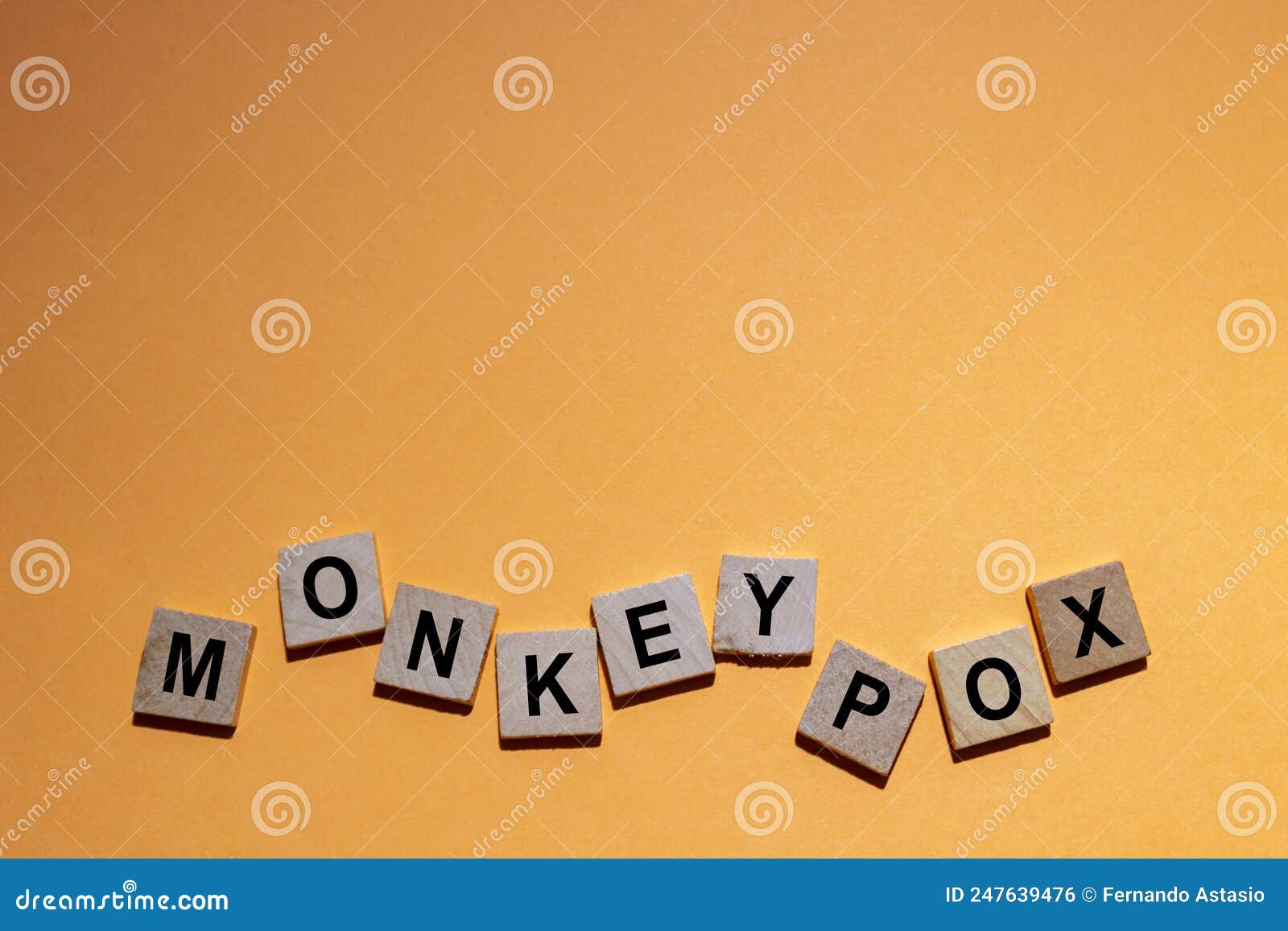 monkeypox. word written on square wooden tiles with an orange background. monkeypox is a zoonotic viral disease