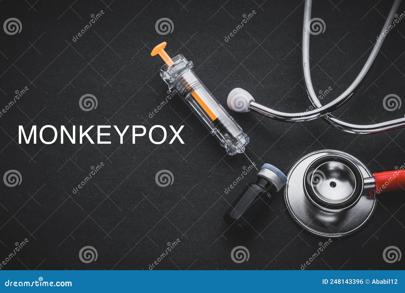 monkeypox words written with stethoscope, syringe, glove and vaccine bottle on black background.