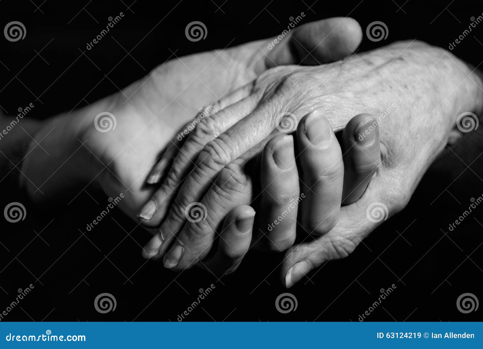 monochrome shot of young woman holding older woman's hand