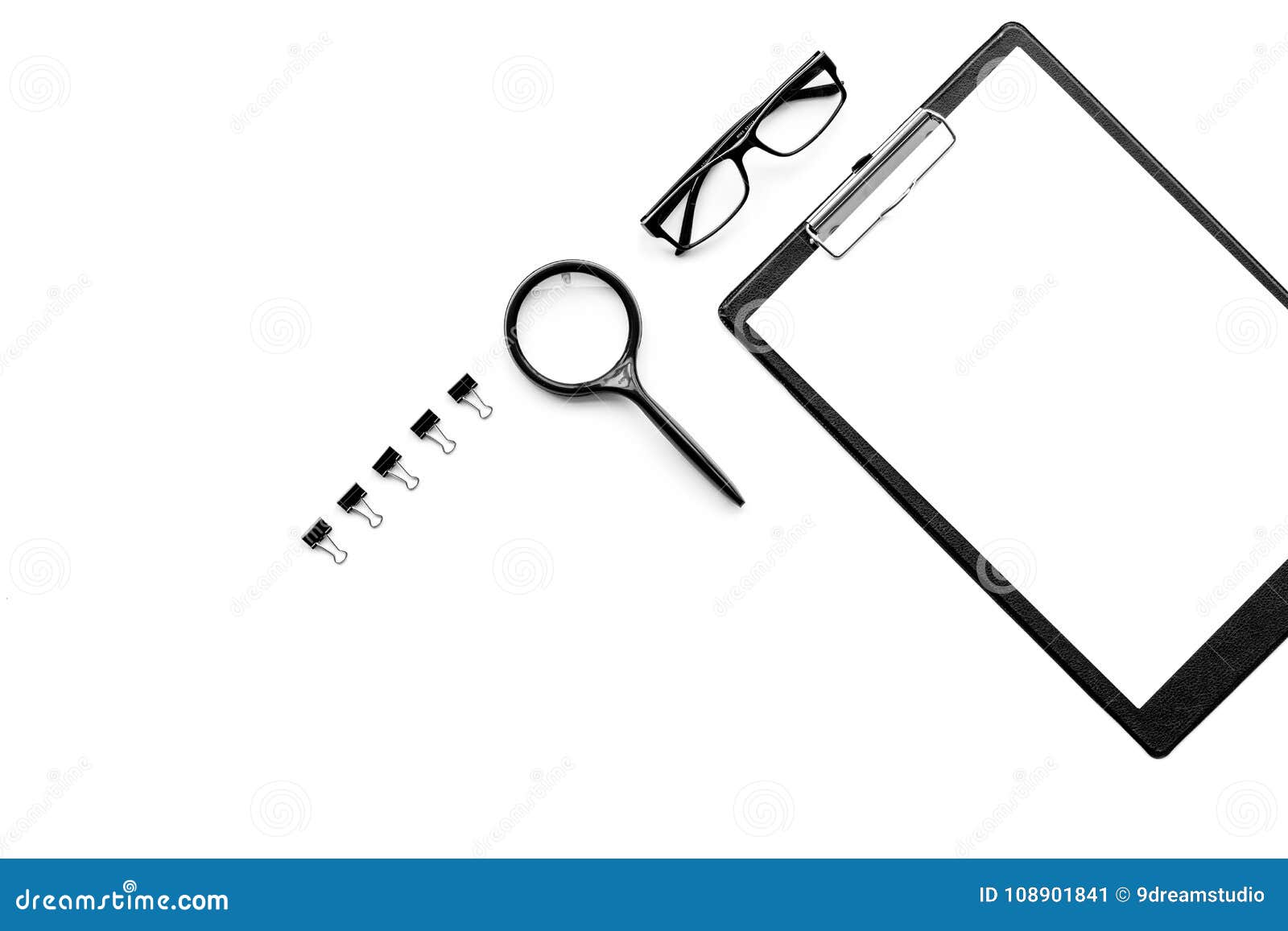 monochrome white and black work desk with pad, glasses, magnifiger on white background top view copy space mock up
