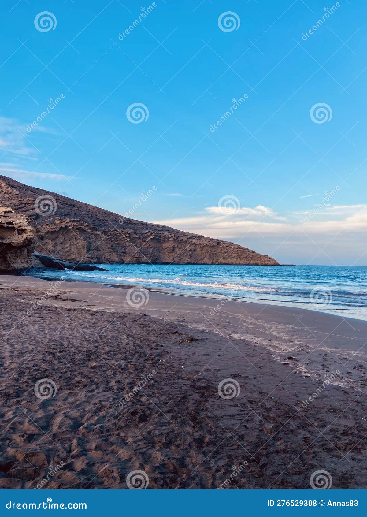 montaÃ±a pelada beach in the evening without people, blue ocean and volcanic mountain, peaceful moment
