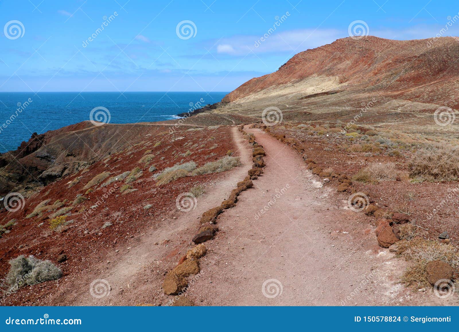montana roja red mountain path in volcanic area with red rocks and soil, ground lava field, el medano, tenerife
