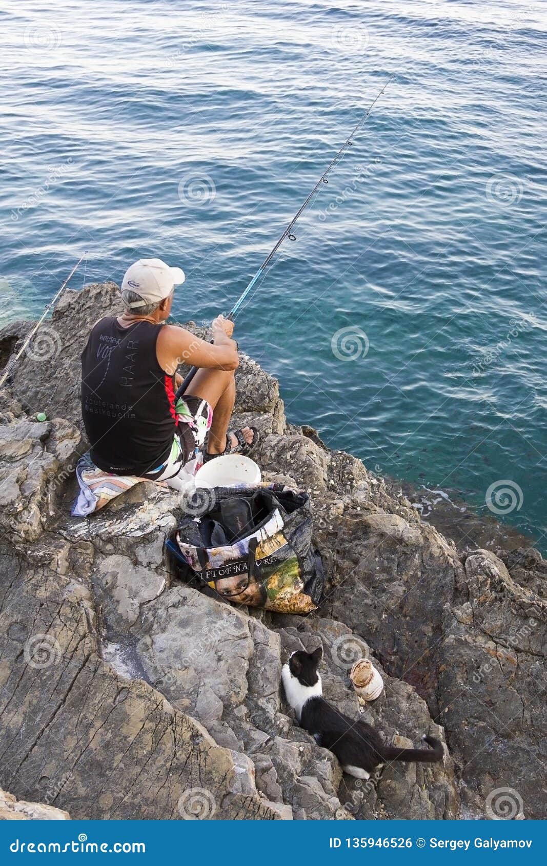 Montenegro, Budva - July 14, 2018: Fisherman Fishing in the Sea on the  Stone Shore, and the Cat is Waiting for the Catch Editorial Photo - Image  of lure, budva: 135946526