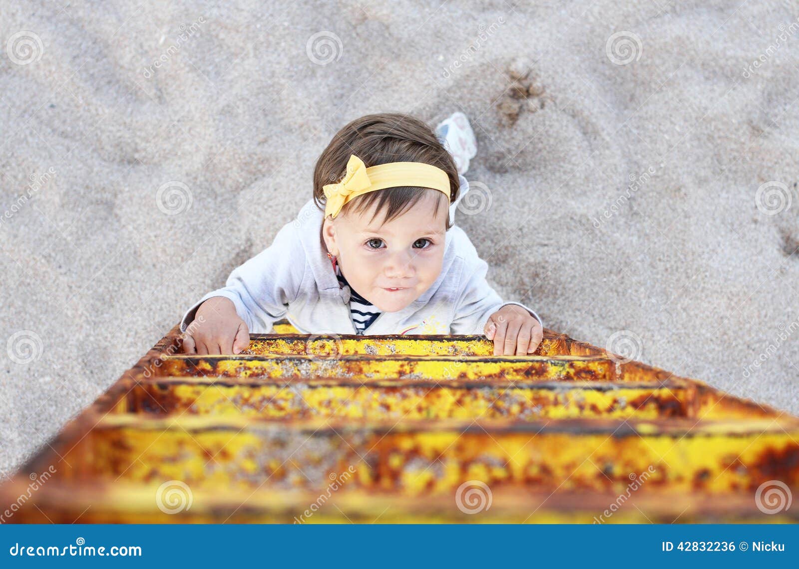 Montée du bébé d'échelle sur la plage