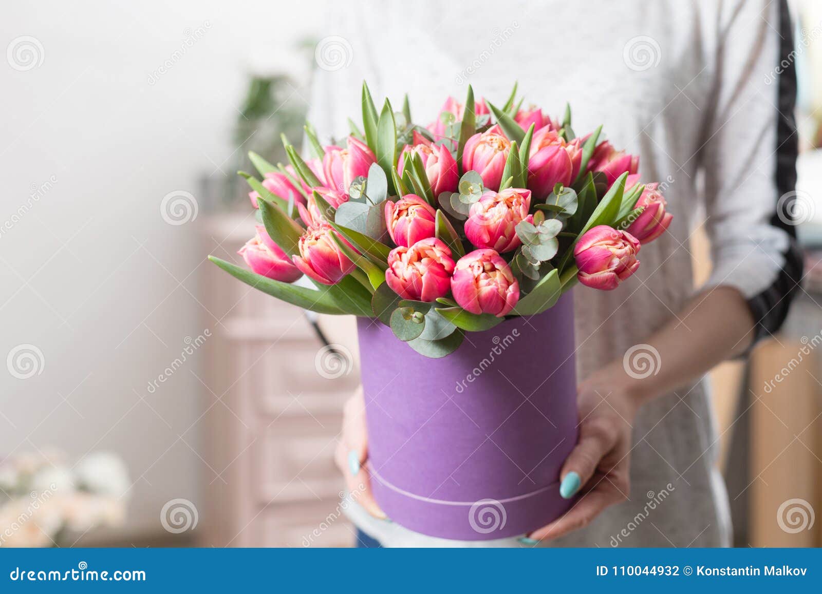 Mooi luxeboeket van roze tulpenbloemen in vrouwenhand het werk van de bloemist bij een bloemwinkel leuk mooi meisje