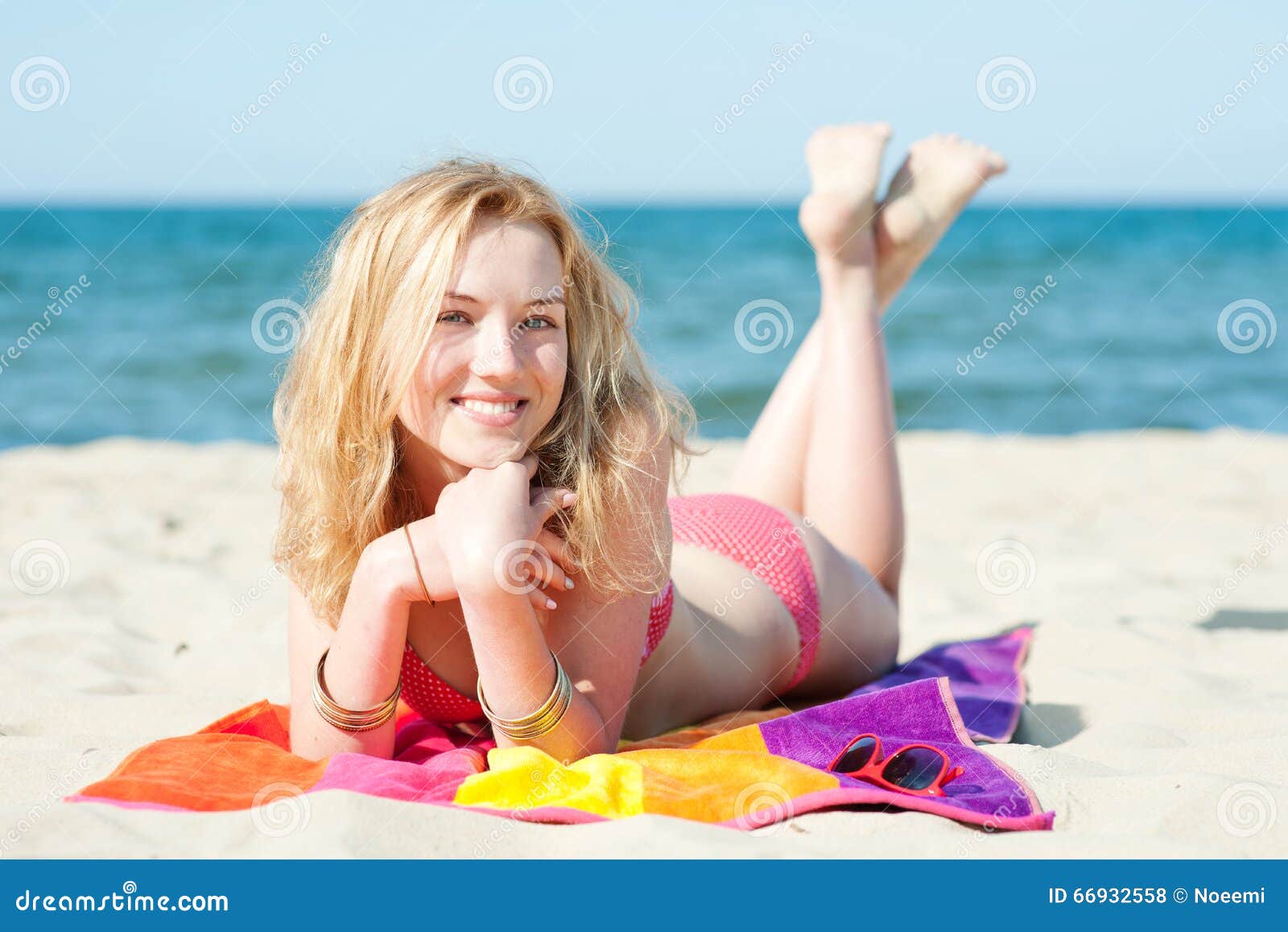 mooie-jonge-blonde-vrouw-die-op-een-strand-liggen-66932558.jpg