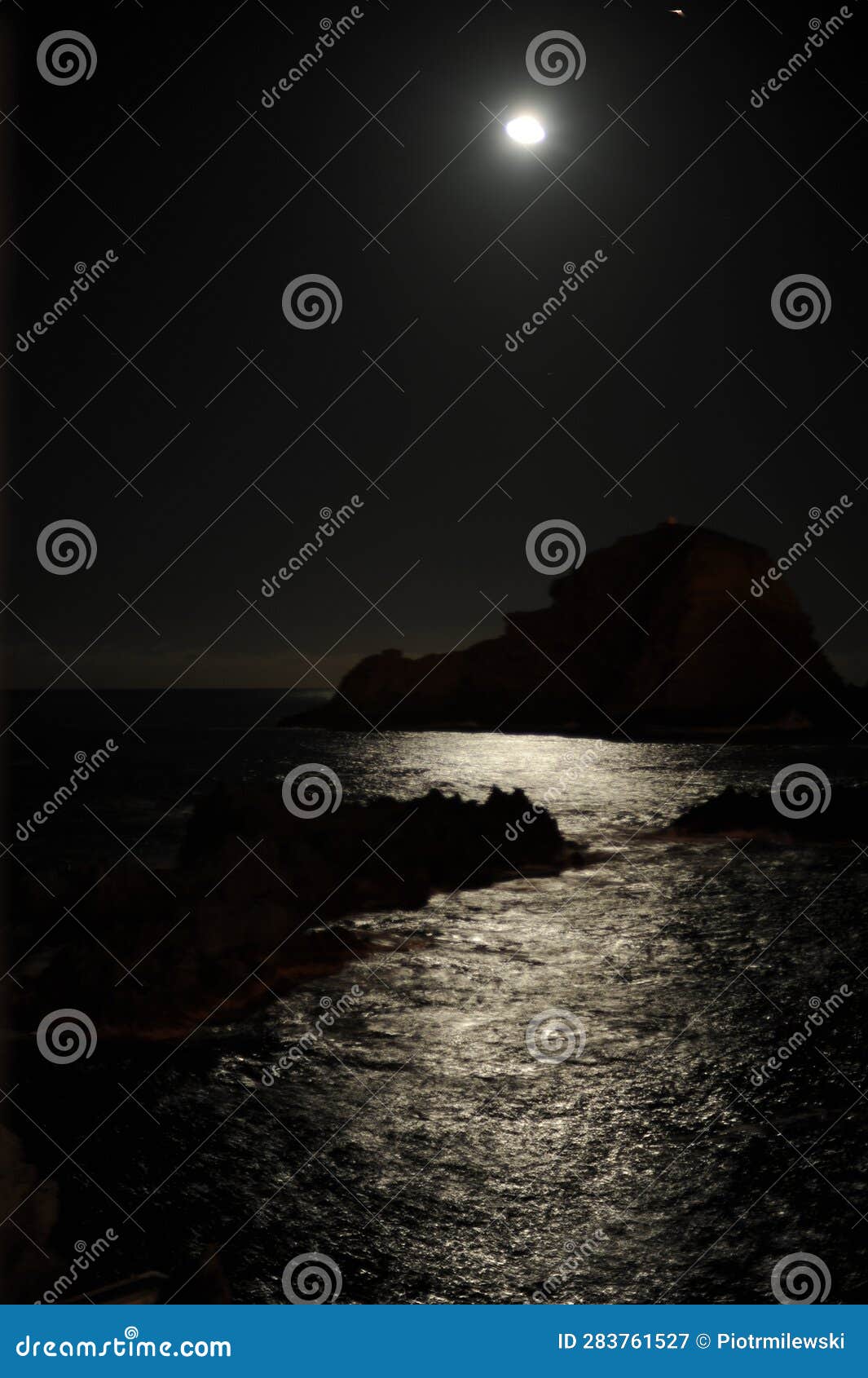 Moonlight of Full Moon Over the Sea at Night with a Rock in the