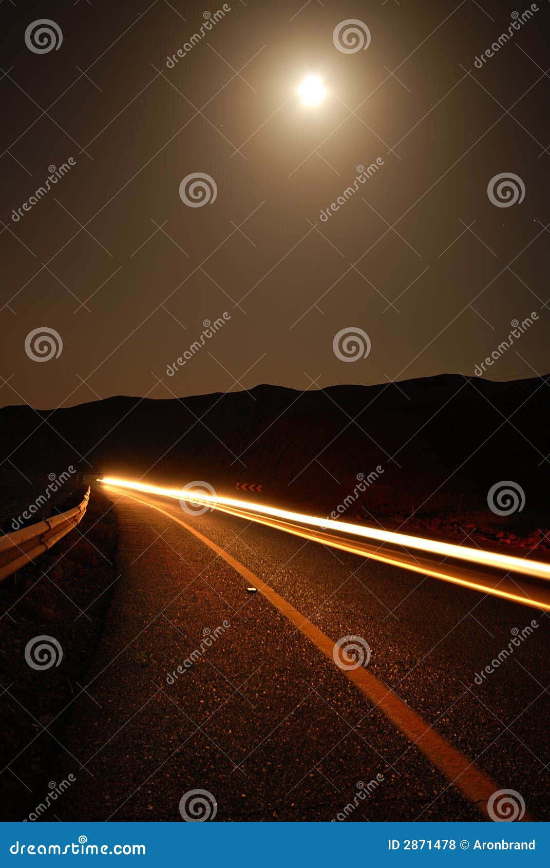 a moonlit road with car trails