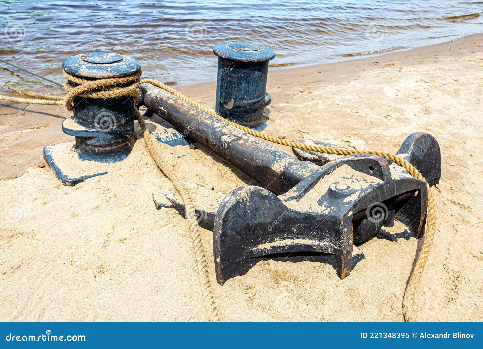 Mooring Bollard with a Fixed Rope and Ship Anchor in the Harbor Stock
