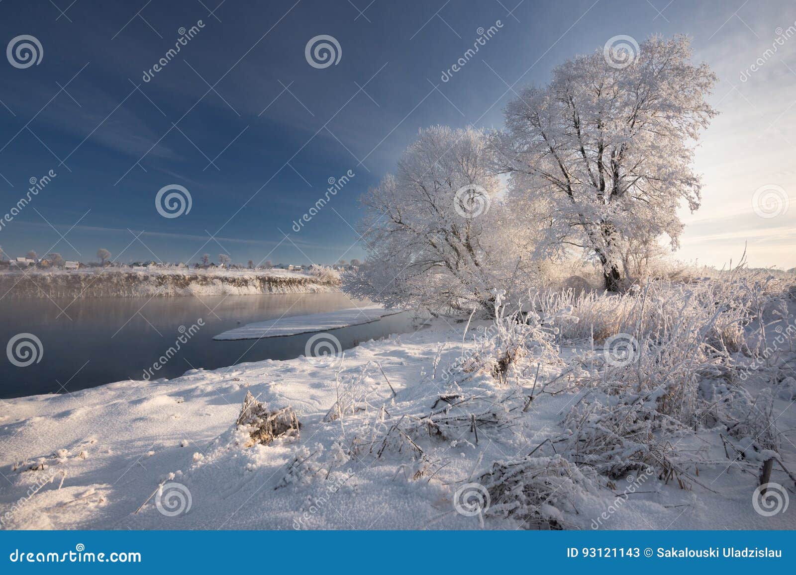 morning frosty winter landscape with dazzling white snow and hoarfrost, river and a saturated blue sky.winter small river on a sun