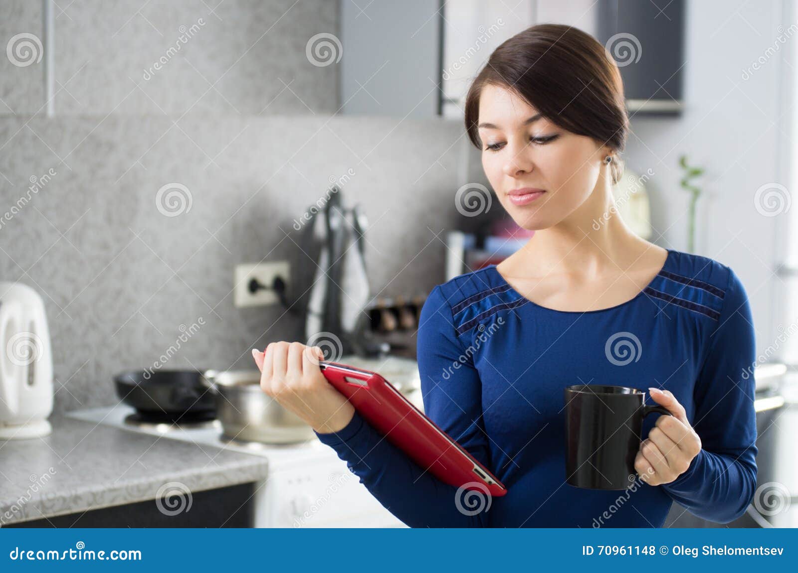 Morning housewife. Portrait of young attractive caucasian brunette housewife at kitchen. Morning with cup of coffee and tablet pc.