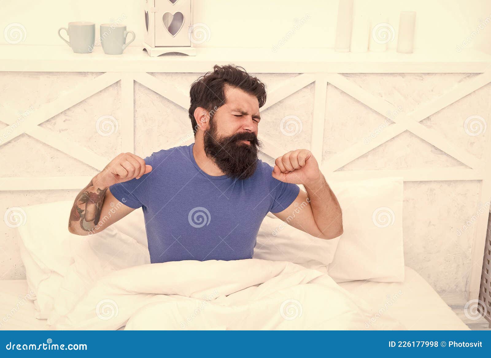 morning sleepiness. peaceful mature male relaxing. bearded man stretching in bed. sleepy guy relax in bedroom. early