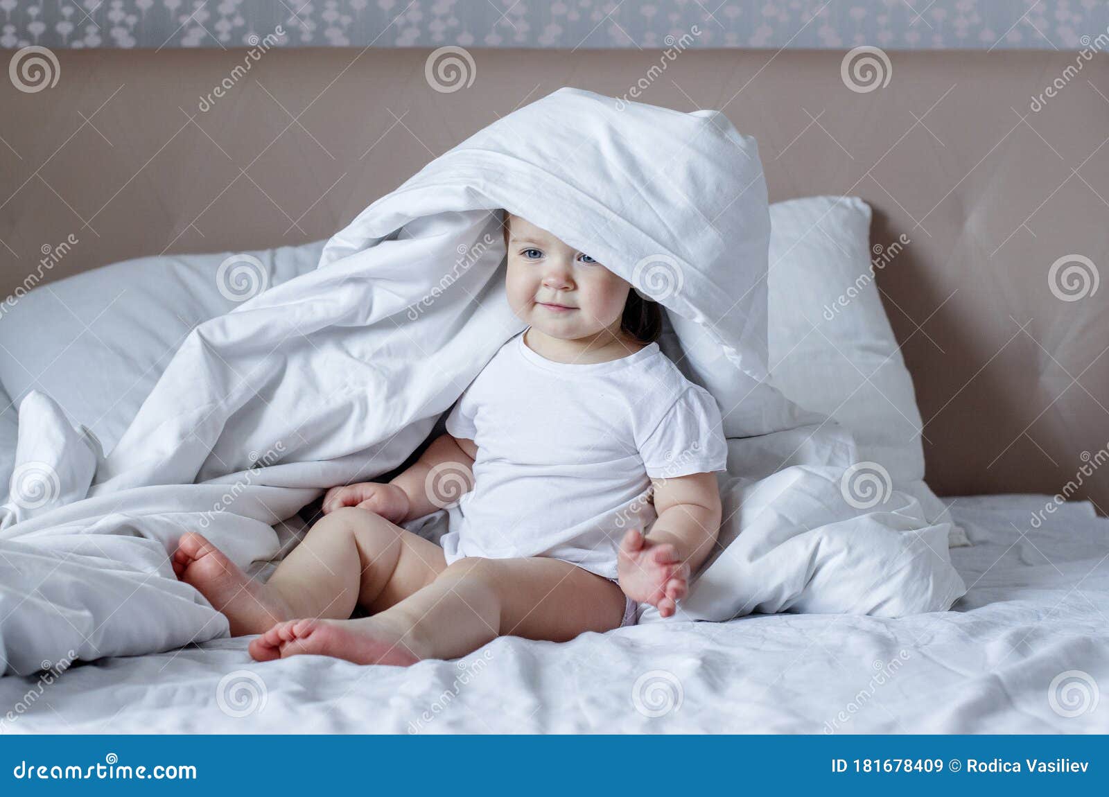 Portrait of a Cute Baby Girl on White Bed in Ligth Interior. Good ...