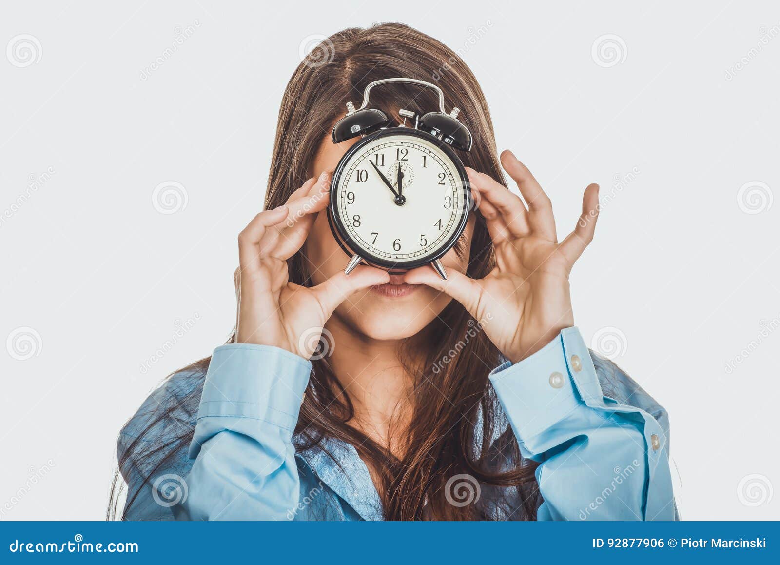 Morning woman in big shirt holding clock. Young morning woman in big shirt holding aralm clock.