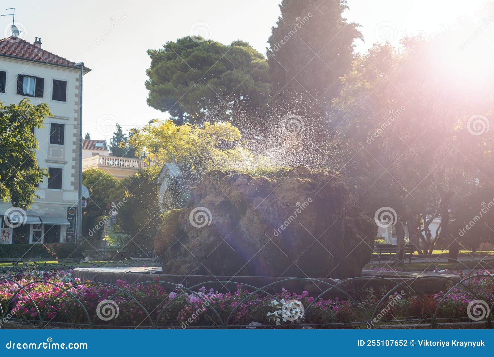 moss covered stone fountain in the park lujo maruna in sunlight. sibenik, croatia