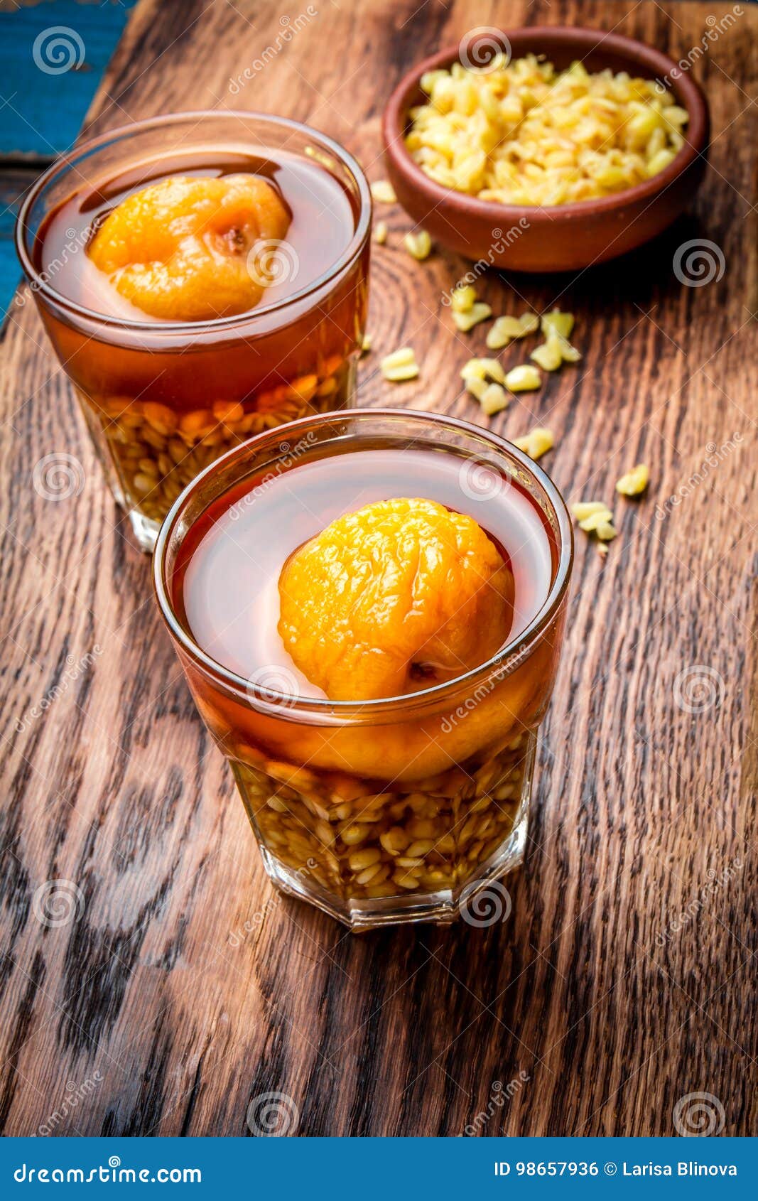 mote con huesillo. traditional chilean drink made from cooked husked wheat and dried peach on wooden board, rustic blue