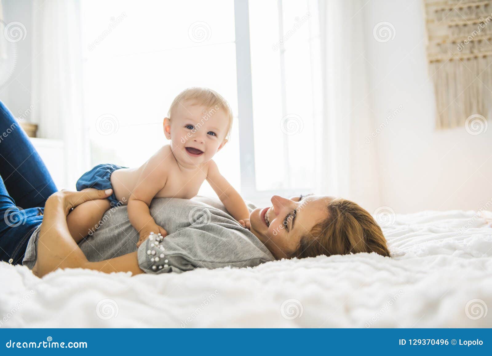 Mother and Baby Girl on Bed Stock Photo - Image of hand, interior ...