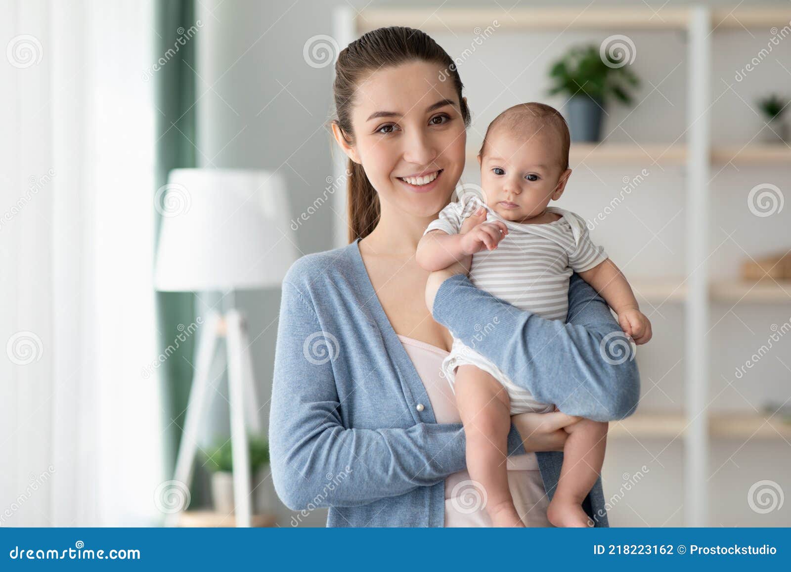 Mother and Baby. Portrait of Beautiful Millennial Mom Holding