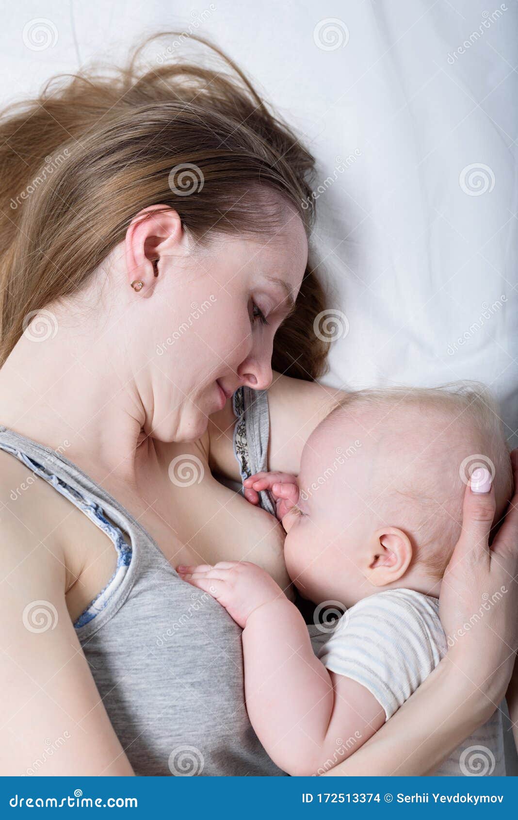 Mother with Cute Baby Lying on Bed. Breast-feeding Stock Photo ...