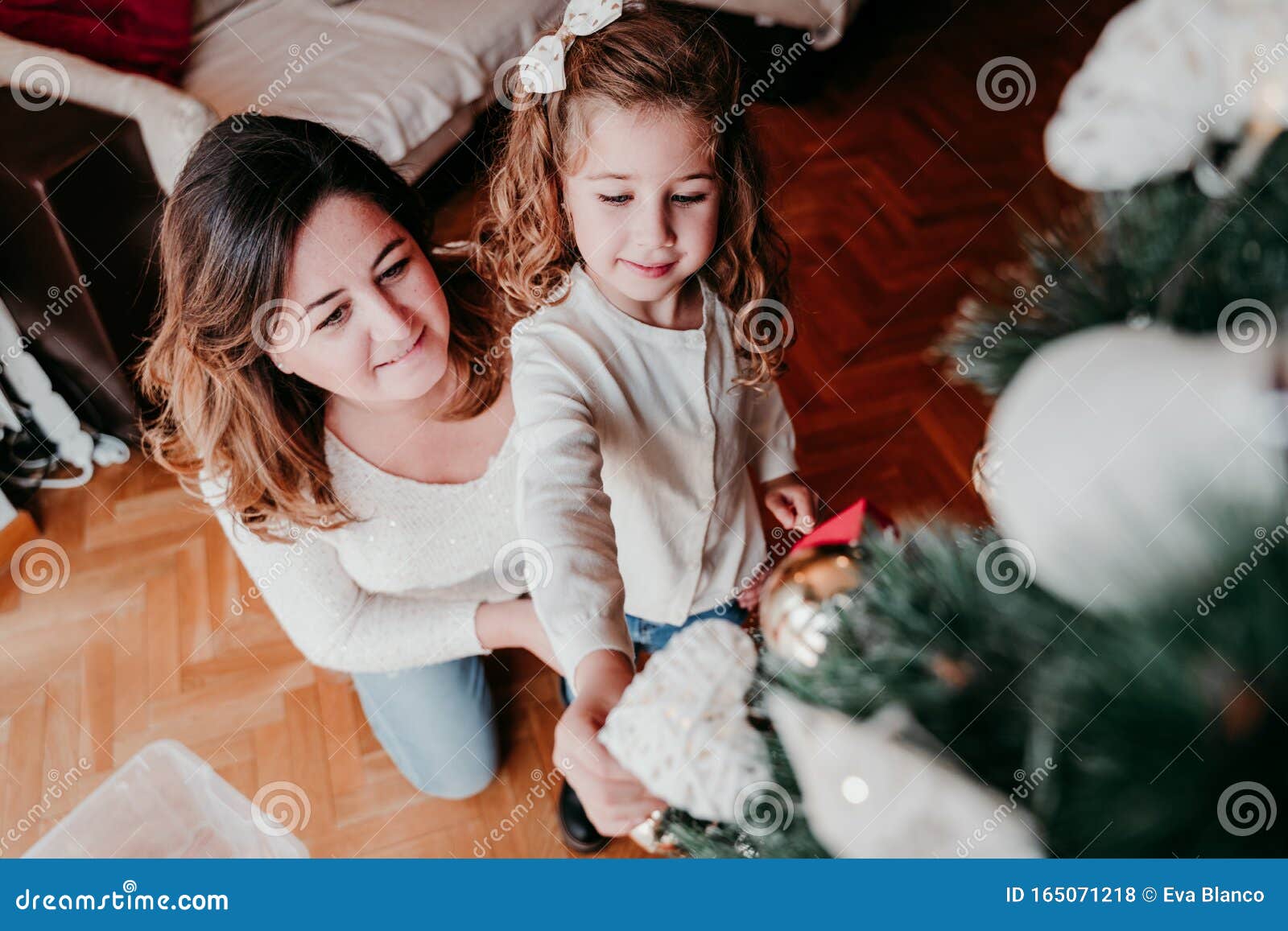 Mother and Daughter Decorating Christmas Tree at Home Stock Photo