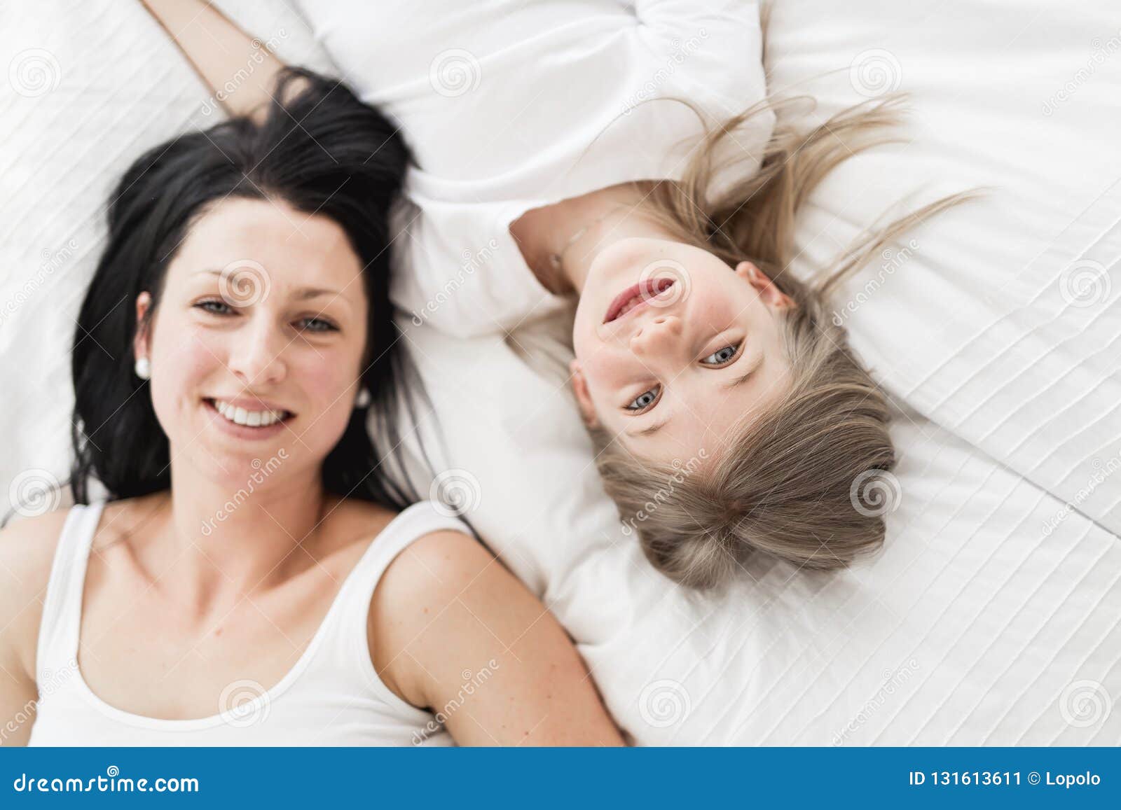 mother and daughter enjoy in bed at home