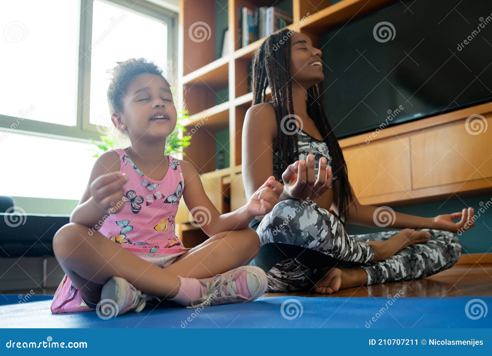 mother and daughter exercising together at home.