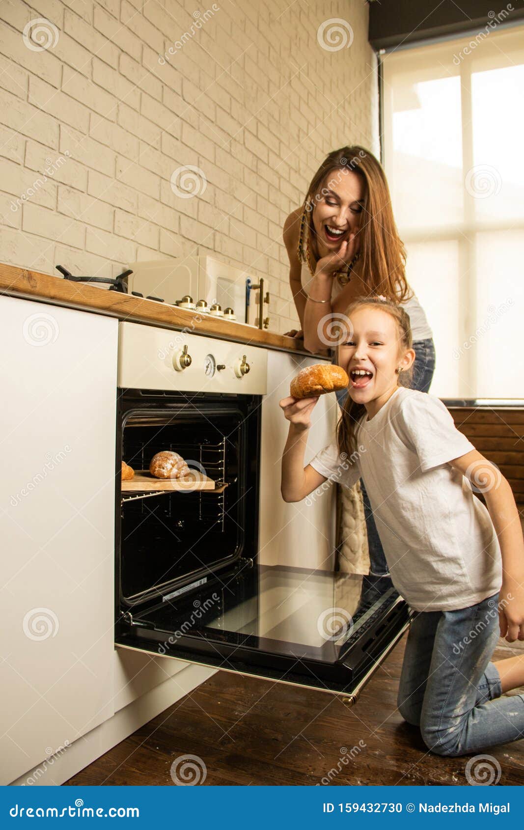Mother And Daughter In The Kitchen, Take Out Baked Goods From The Oven