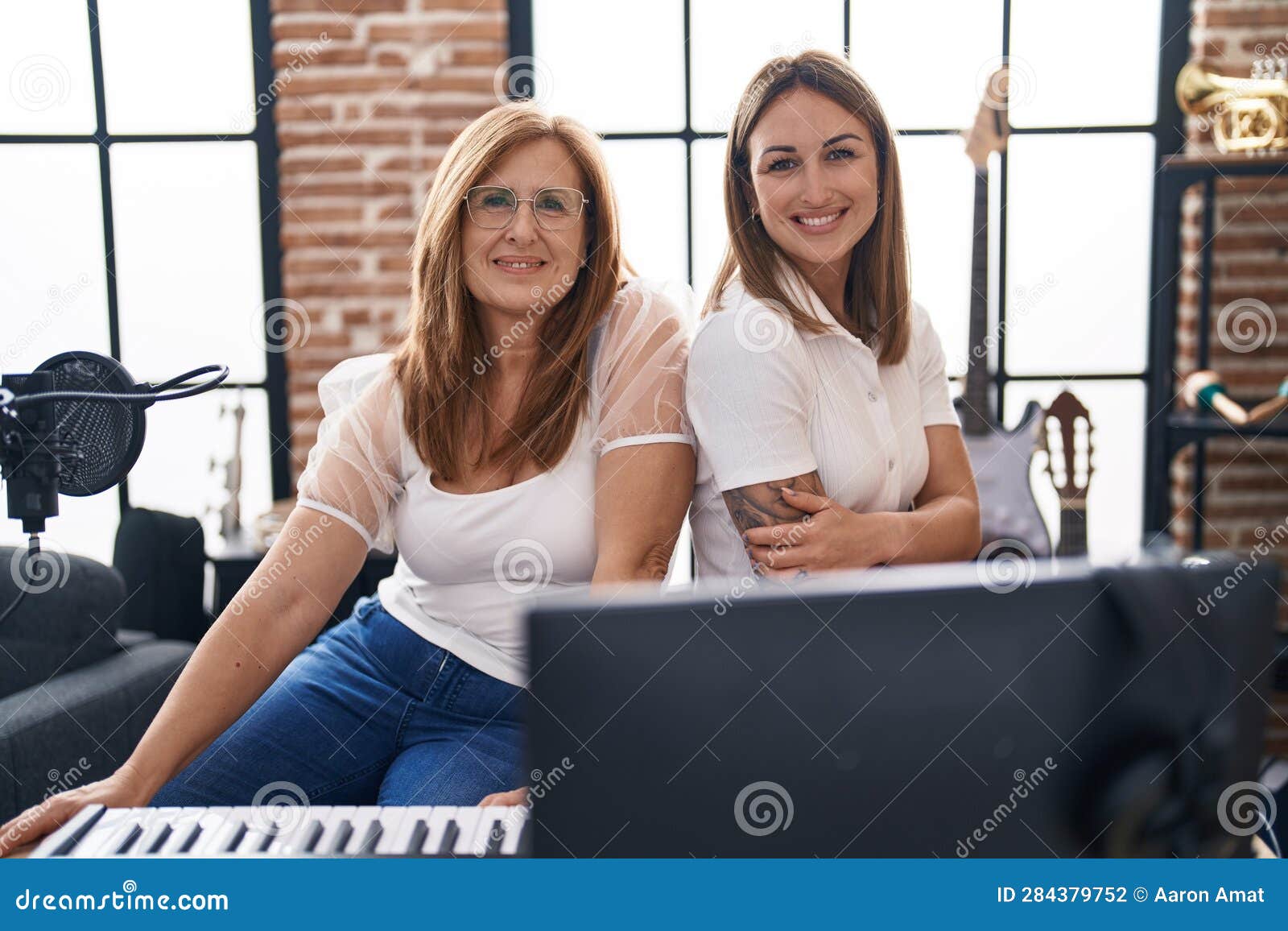 Mother and Daughter Musicians Smiling Confident at Music Studio Stock