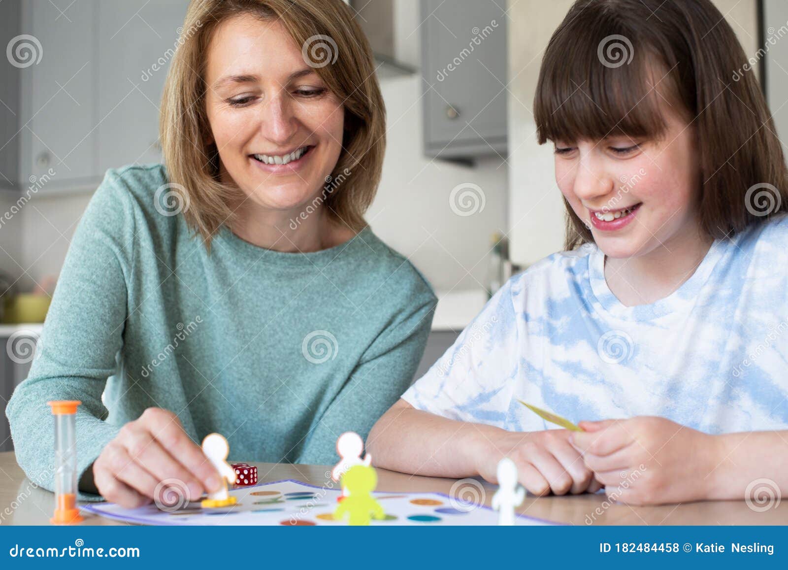 Mother and Daughter Playing Generic Board Game at Home Stock Photo