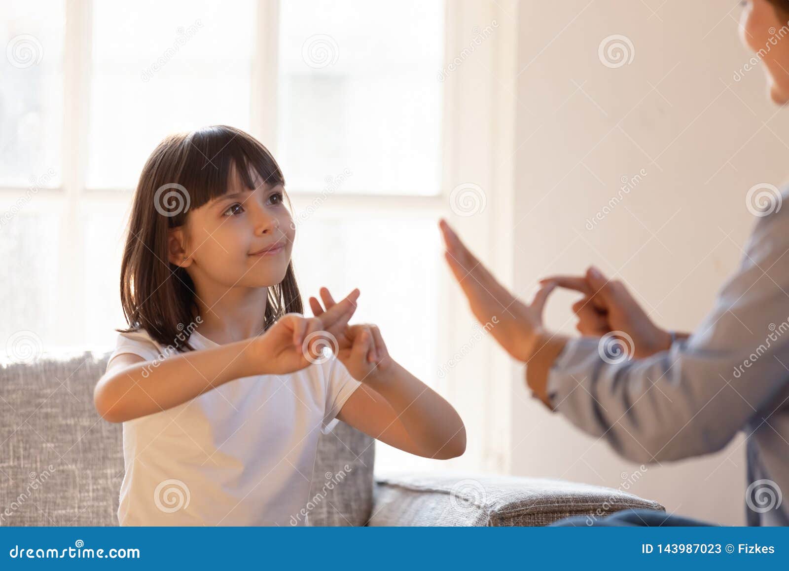 mother daughter sitting on couch nonverbal communicating with sign language