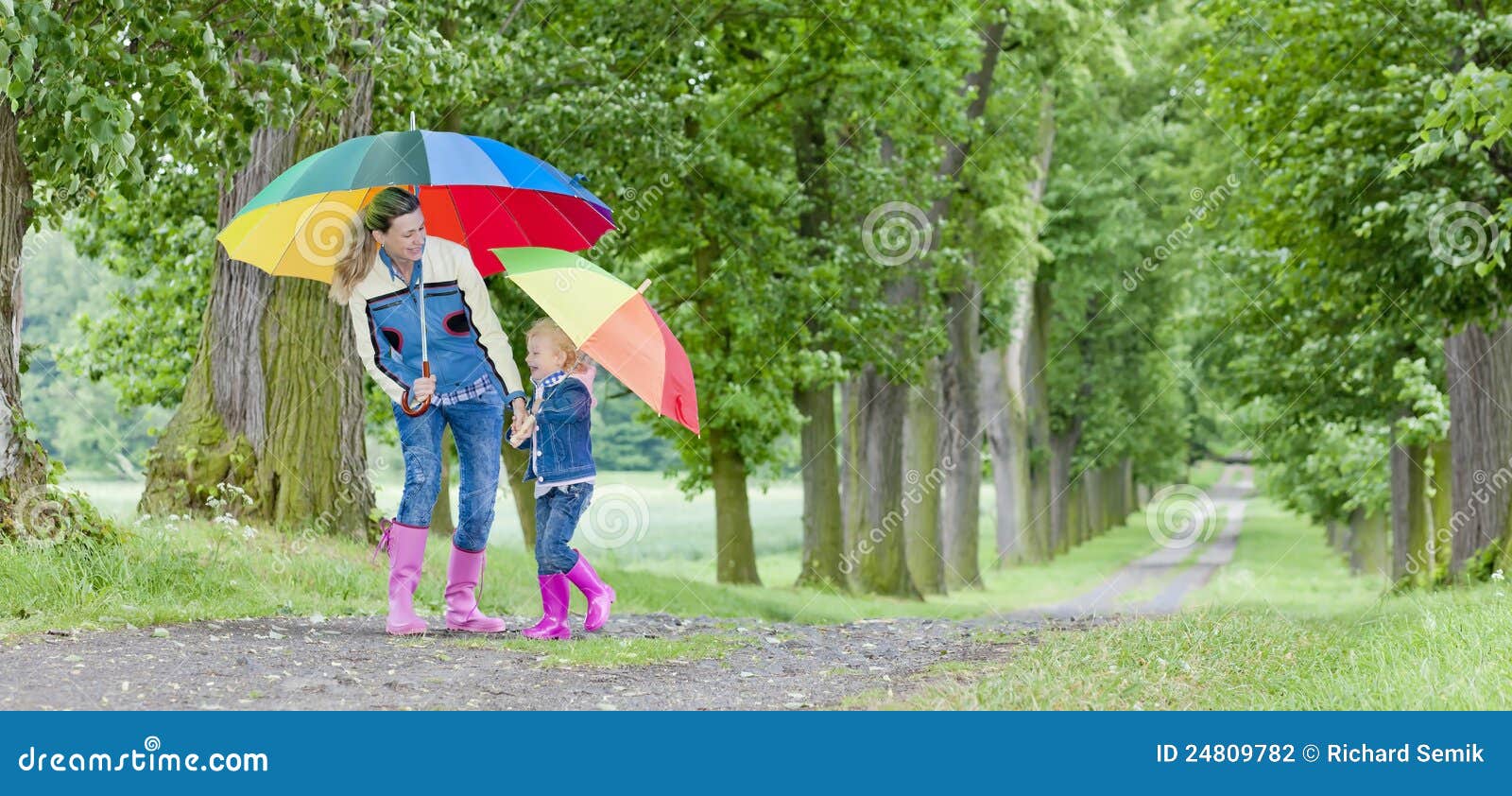 Mother and daughter with umbrellas. Mother and her daughter with umbrellas in spring alley