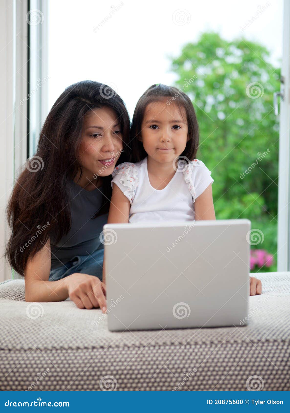 Hispanic Mother And Daughter Using Computer At Home Stock 