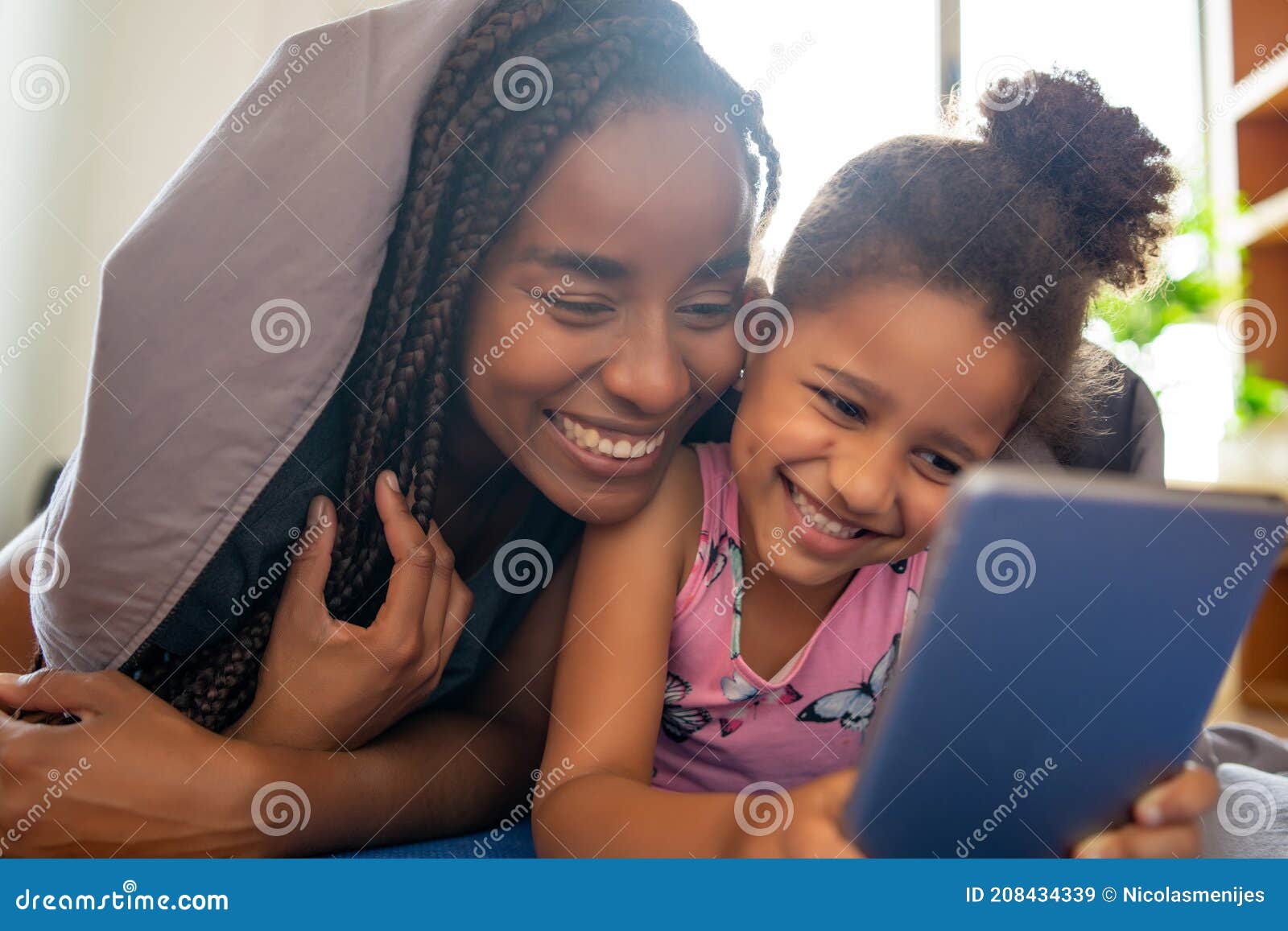 mother and daughter using digital tablet at home.