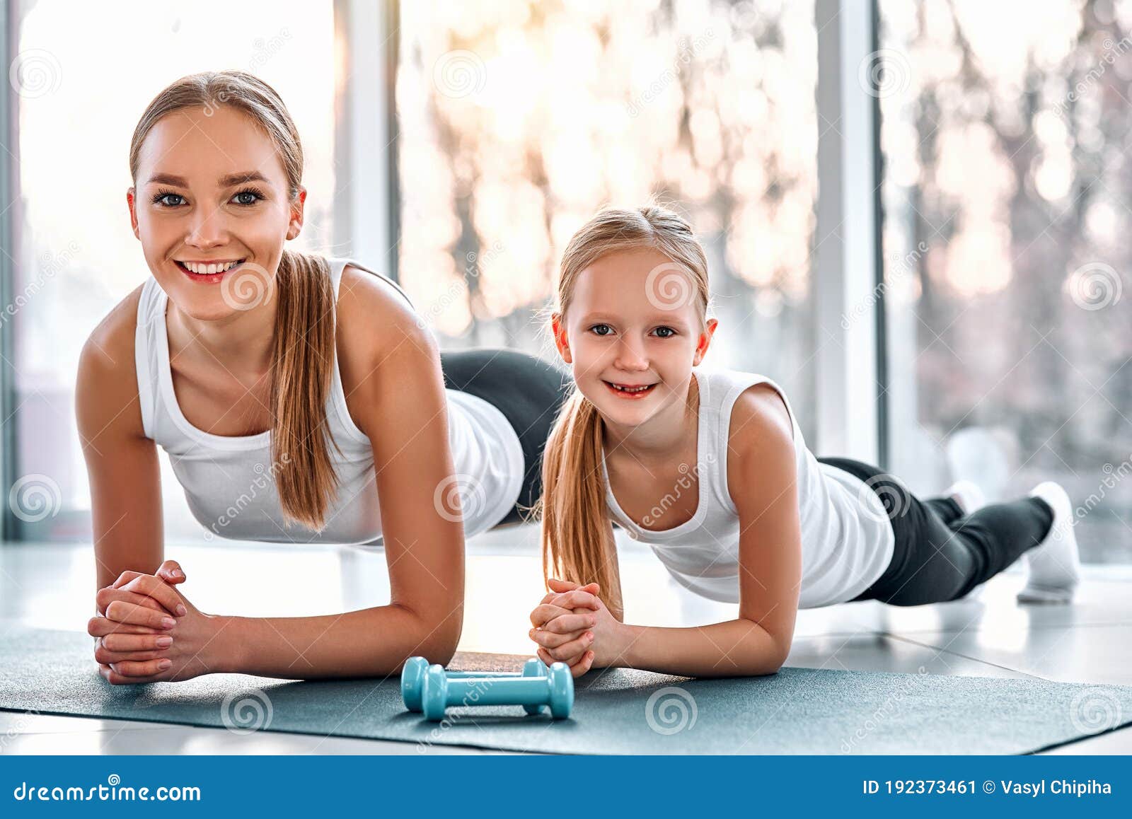 Mother And Daughter Working Out Together Doing Plank Exercise Stock