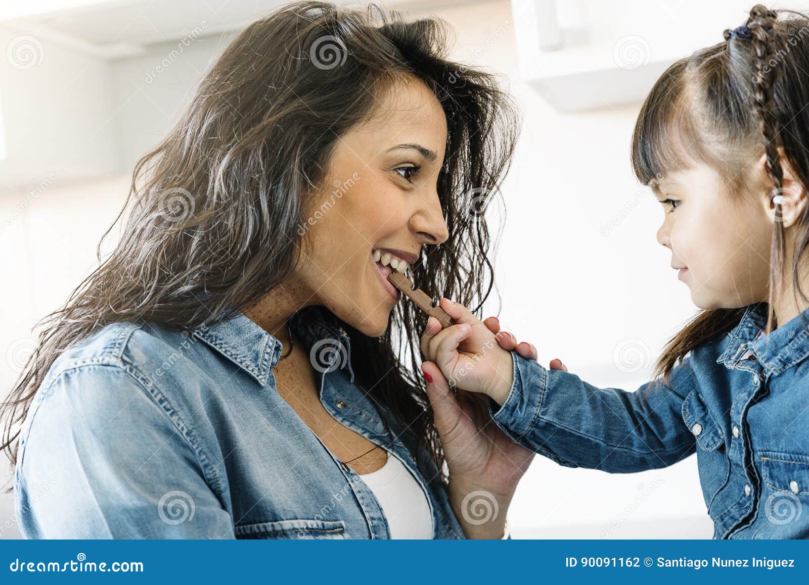 Mother Eating Chocolate with Her Daughter. Stock Photo Image of