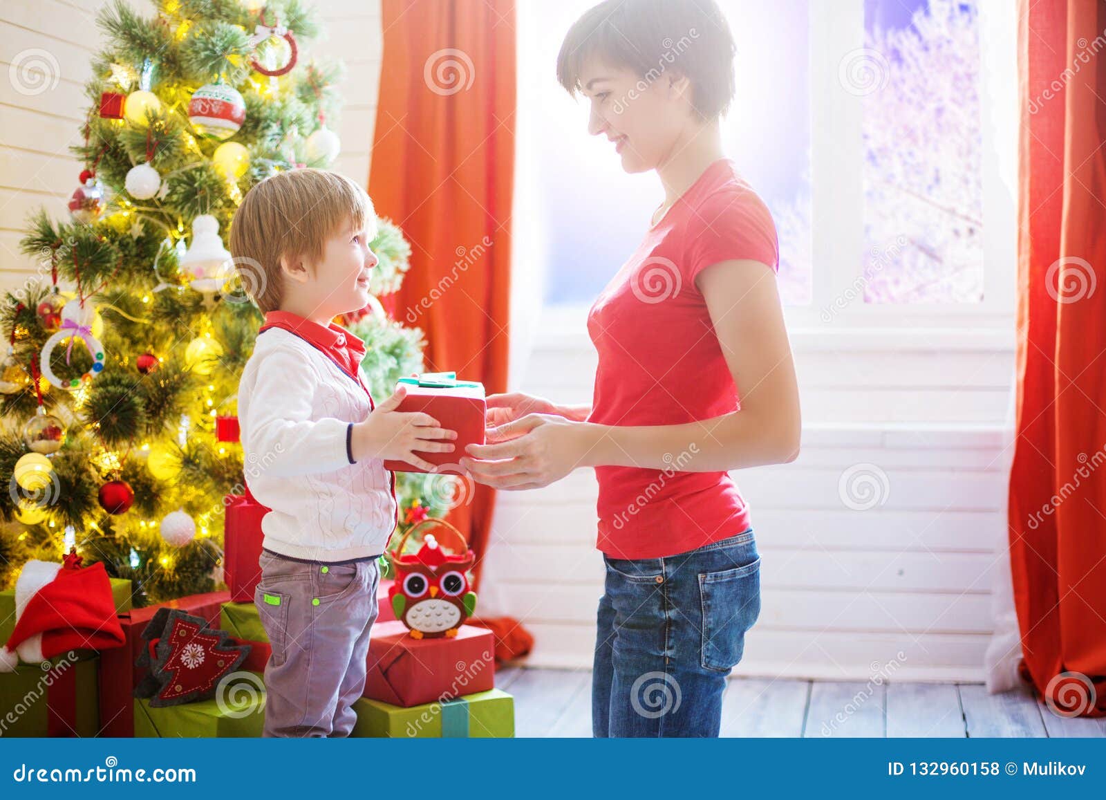 Mother Gives a Gift To Her Son for Christmas or Son Gives a Gift To His