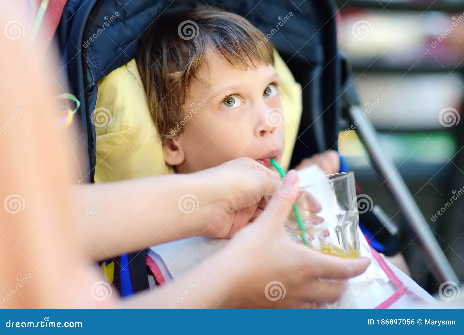 Mother Giving Disabled Child A Drink. Cute Little Girl ...