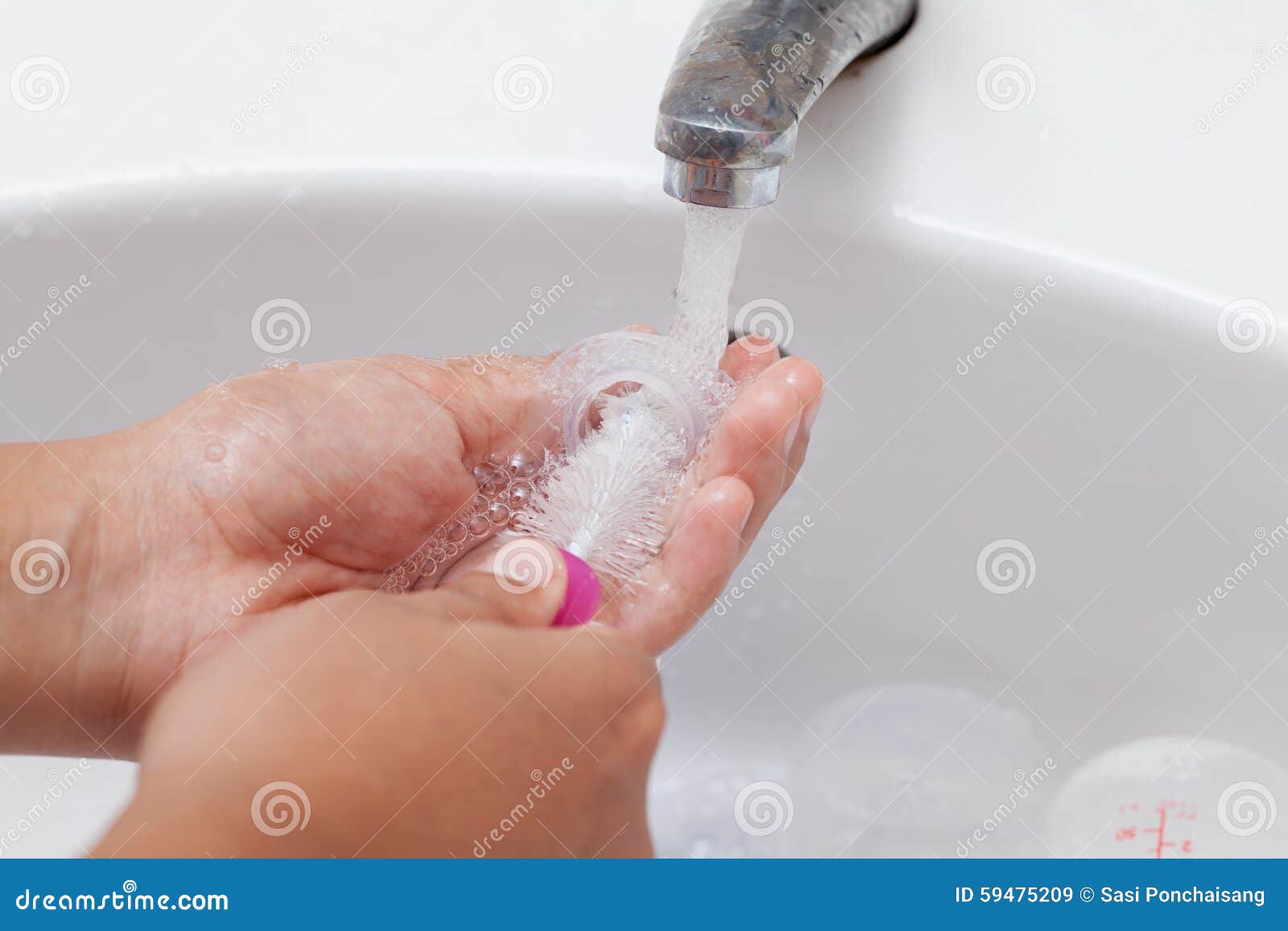 Mother Hand Washing Baby Plastic Nipple on White Sink Stock Image