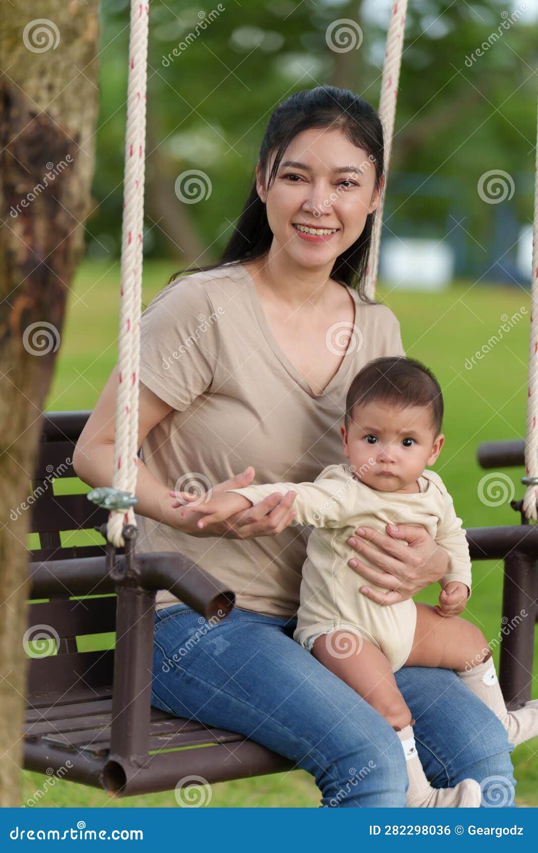 Mother with Her Baby Sitting on a Swing in Park Stock Photo - Image of ...