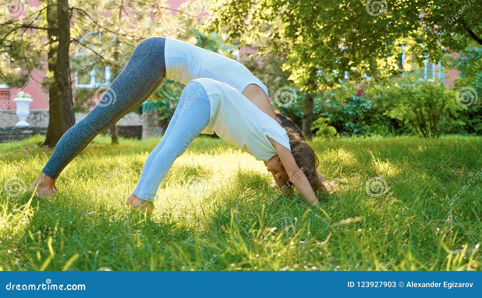 Mother And Her Little Cute Daughter Doing Yoga Exercise