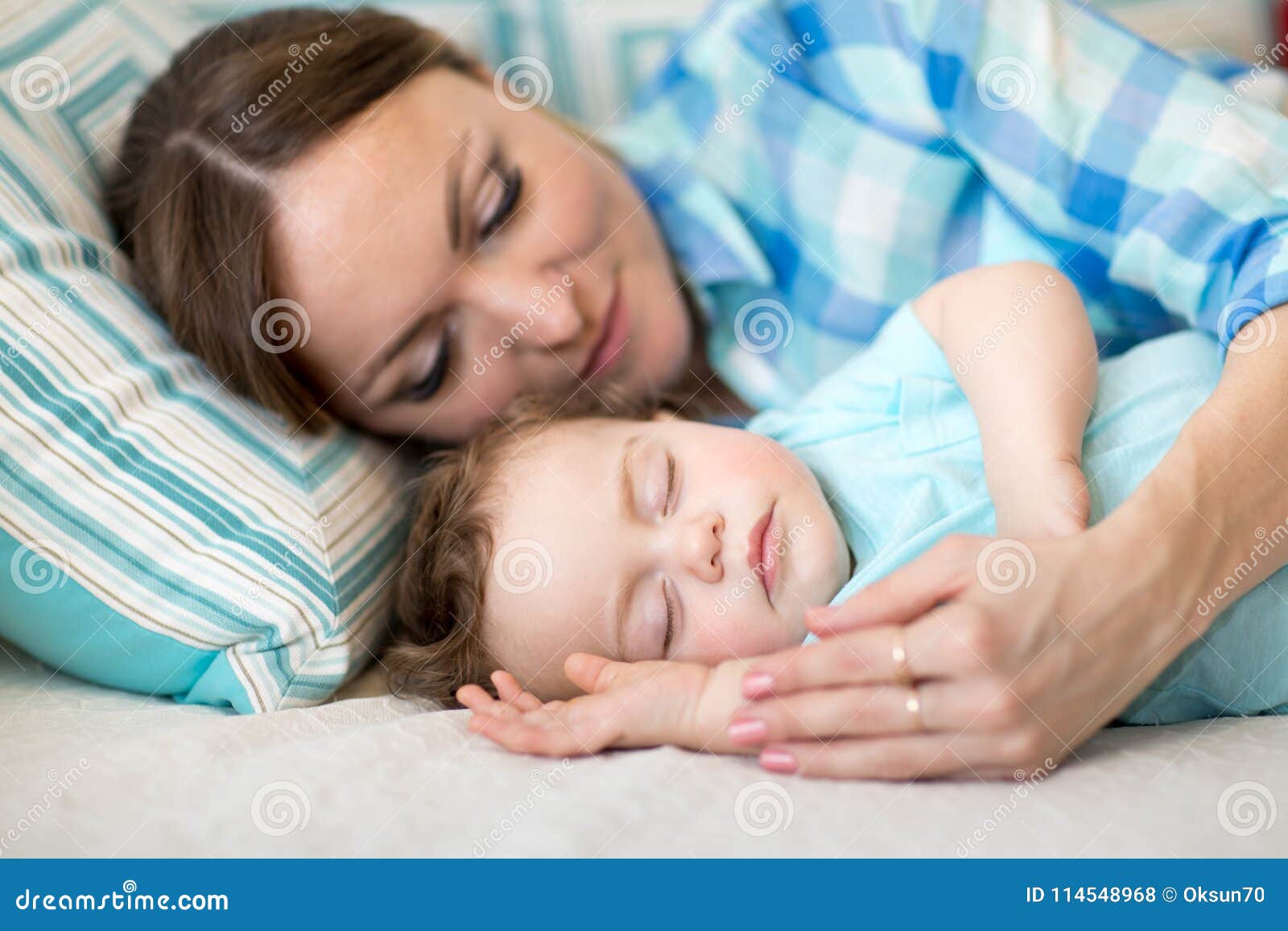 Mother And Her Son Baby Sleeping Together In A Bedroom Stock Photo