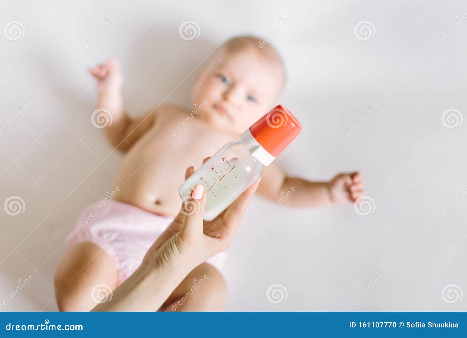 Mother Holding And Feeding Baby From Bottle Stock Photo