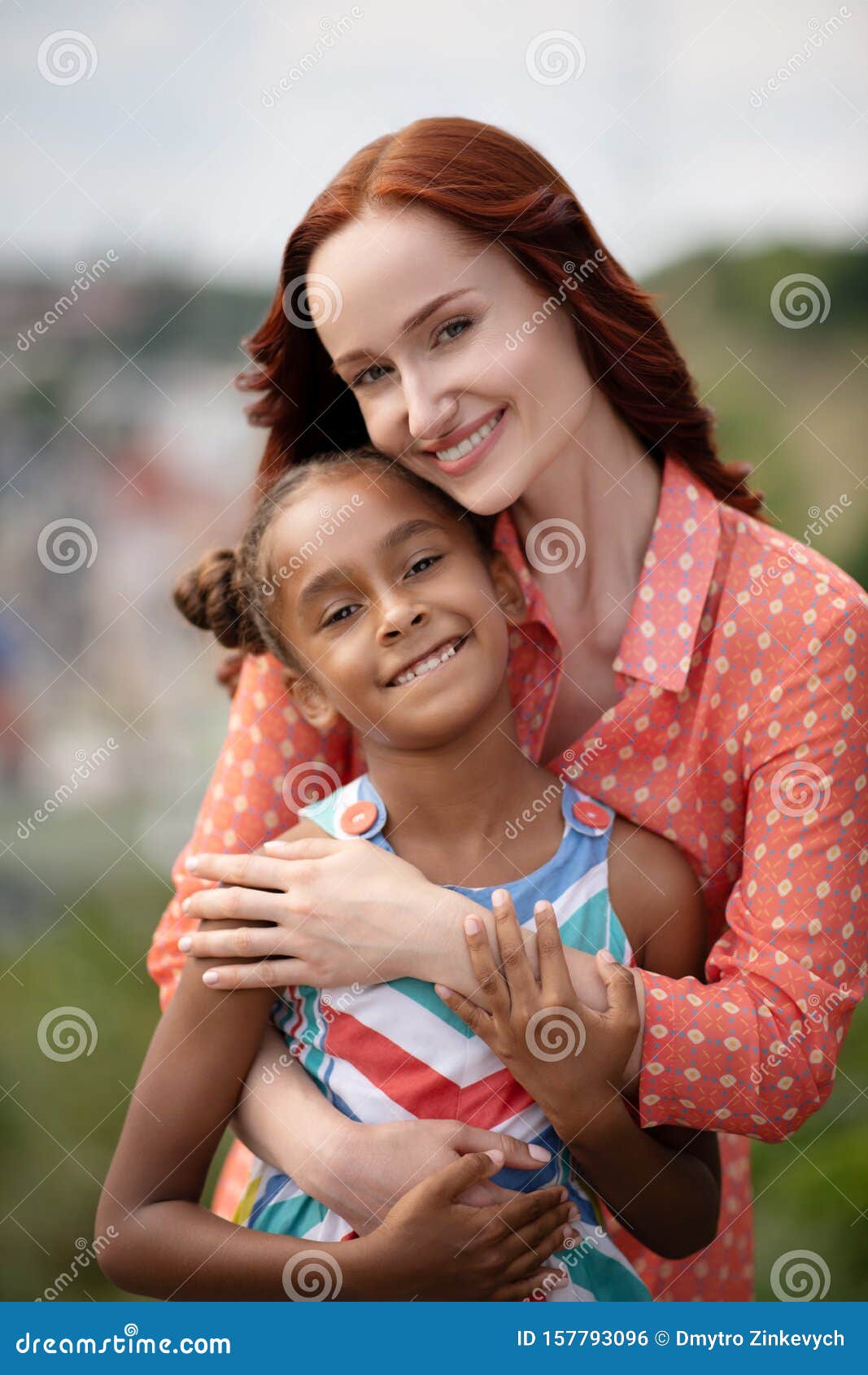 beaming foster mother hugging her cute lovely girl