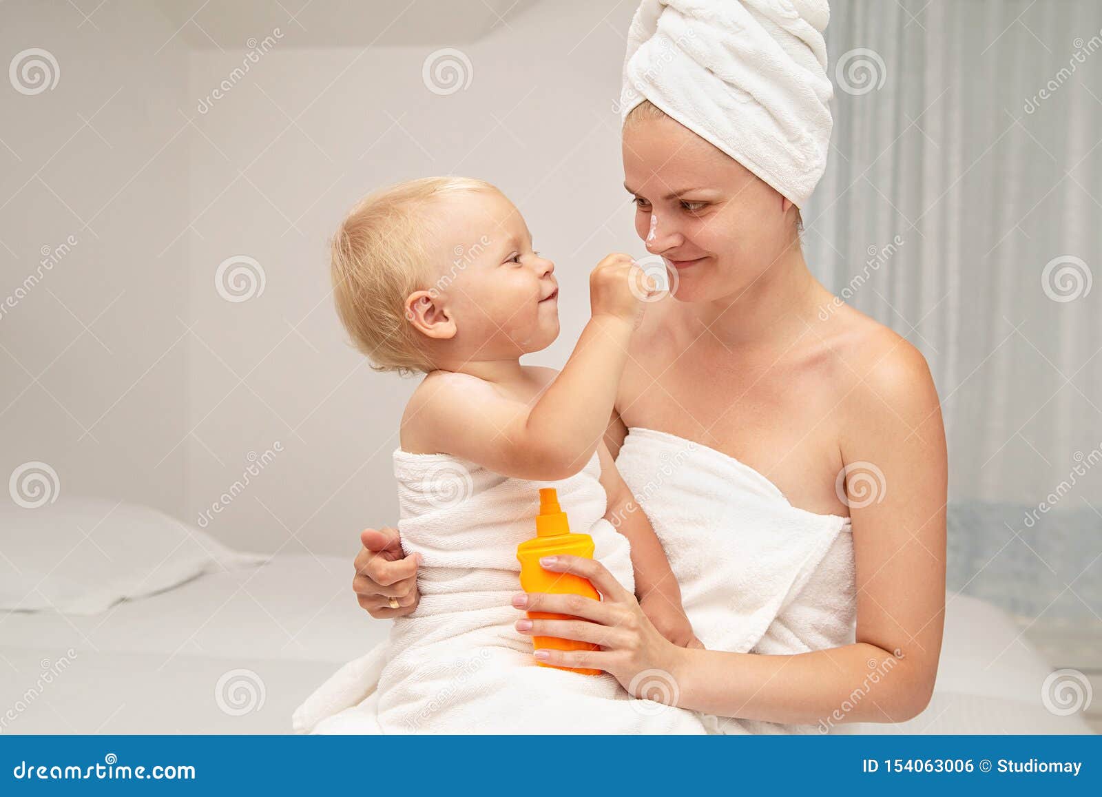 Mother And Infant Baby Boy In White Towels After Bathing Apply