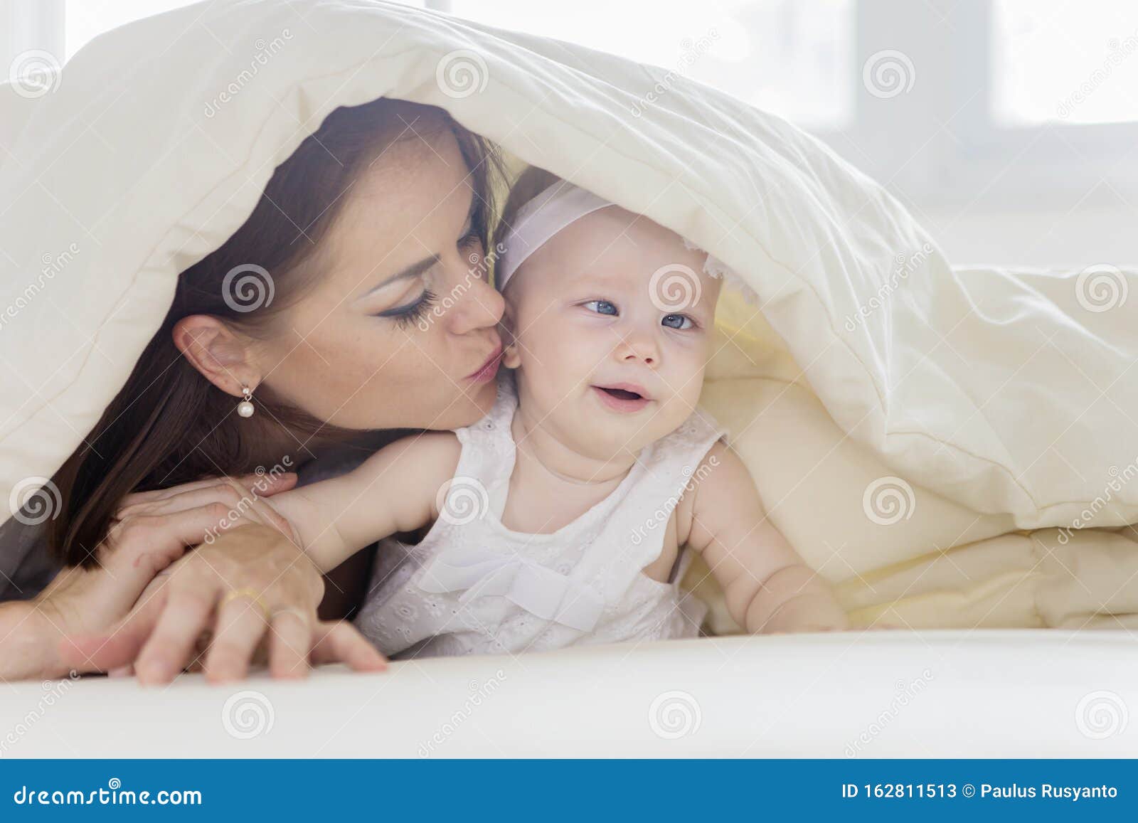 Mother Kissing Her Baby Under a Blanket Stock Image - Image of ...