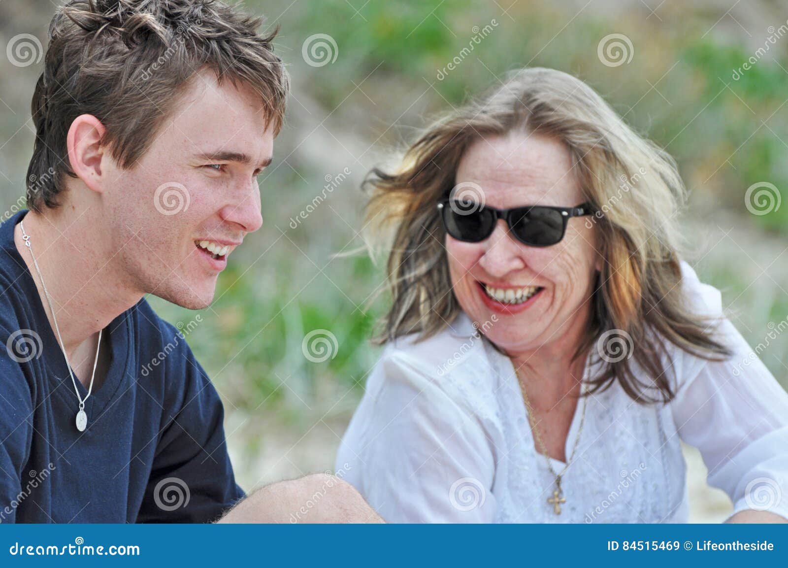 mother laughing smiling loving sharing time with son on summer beach holiday