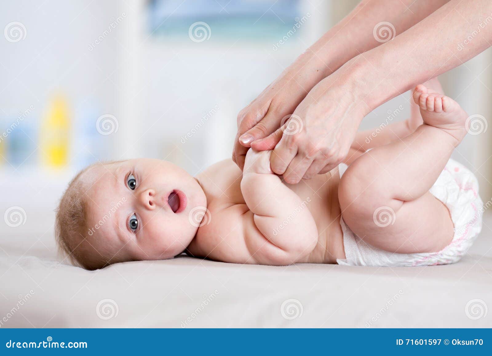 mother massaging her baby girl